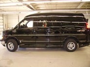 Fully assembled black conversion van inside workshop