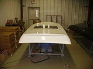 Worker installing a van roof inside a workshop