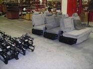 Van seats and seat frames arranged in workshop for installation